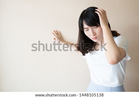 Young asian female suffering from dizziness, vertigo and headache over white background. Cause of dizzy inclued migraine, stress, stroke, BPPV, Meniere’s disease or brain tumor. Health care problem. Royalty-Free Stock Photo #1448105138