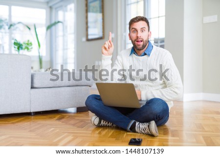Handsome man wearing working using computer laptop pointing finger up with successful idea. Exited and happy. Number one.