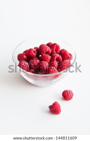 Raspberries in a transparent glass bowl