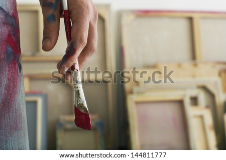 Closeup of an artist holding paintbrush Royalty-Free Stock Photo #144811777