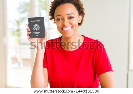 Young african american woman holding passport of United States of American with a happy face standing and smiling with a confident smile showing teeth