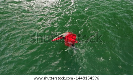 Aerial top view photo of hydrofoil wind surfer in tropical bay with emerald open ocean sea