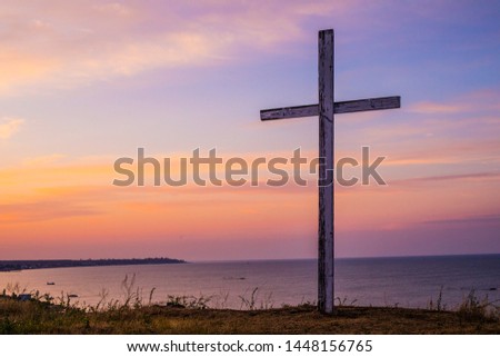 Jesus Christ cross. Easter, resurrection concept. Christian illustration of a Dramatic Sky with Large wooden Cross standing on the background of sunset or sunrise.