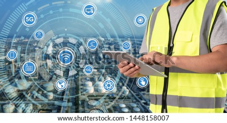 worker working on pad with oil and gas refinery background, Royalty-Free Stock Photo #1448158007
