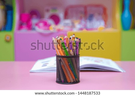 Pen, pencil and accessory in black basket isolated on blured  background .Colored pencils in a pencil case on blured background