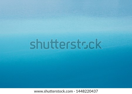 Background azure blue expanse of the sea with small ripples on the water. Transition from light blue to dark blue
