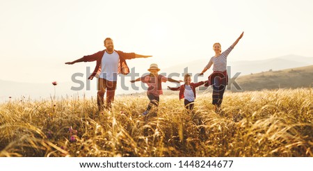 Happy family: mother, father, children son and  daughter on nature  on sunset
 Royalty-Free Stock Photo #1448244677