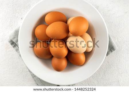 Brown eggs in plate on a white background with copy space top view