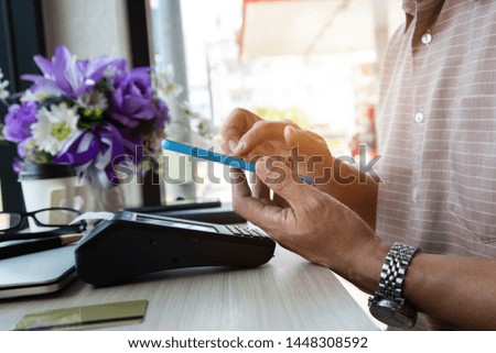 A businessmen scan cellphone on Card payments  via credit card machine in coffee shop, banking concept.business concept, soft focus, vintage tone