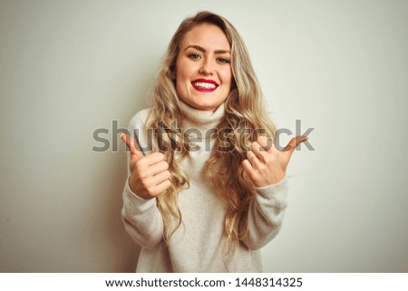 Beautiful woman wearing winter turtleneck sweater over isolated white background success sign doing positive gesture with hand, thumbs up smiling and happy. Cheerful expression and winner gesture.