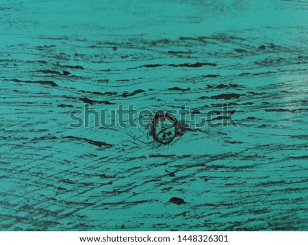 closeup of weathered wood surface with grain and pealing turquoise paint