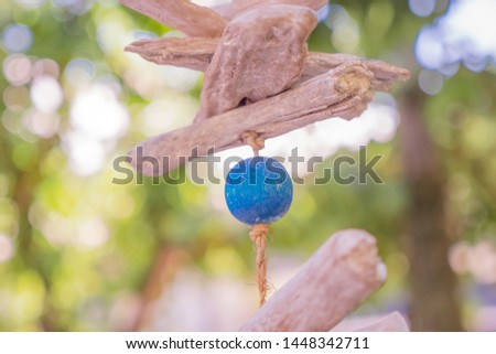 Wooden ball with park on background. Wooden mobile of blue ball. Wooden baby mobile. Wind singer with park, yard on background. Wooden toys hanging on the rope. Eco toys background.