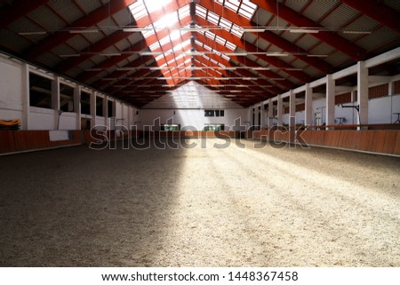 Picture of an empty indoor horse riding hall. Horizontal view in an indoor riding arena