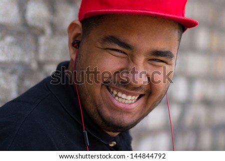 Young black boy in headphones laughing. Portrait of happy African male person listening to music outdoor