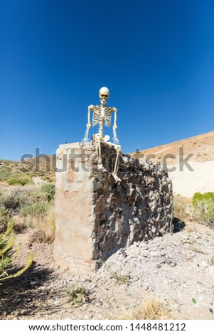 Skeleton posing in mining ruins in the desert on a hot day