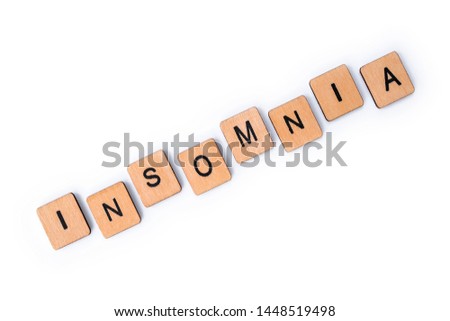 The word INSOMNIA, spelt with wooden letter tiles over a white background. 