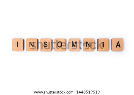 The word INSOMNIA, spelt with wooden letter tiles over a white background. 