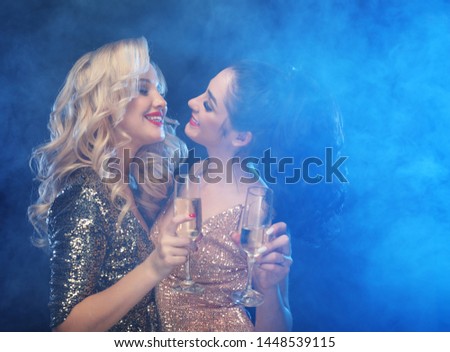 lifestyle, friendship, party and people concept - Two glamour women in luxury glitter sequins dress drinking champagne and having fun