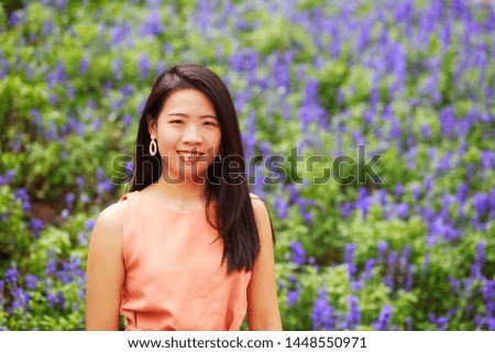 Vintage style portrait photography of pretty Asian girl in flower park, selected focus.