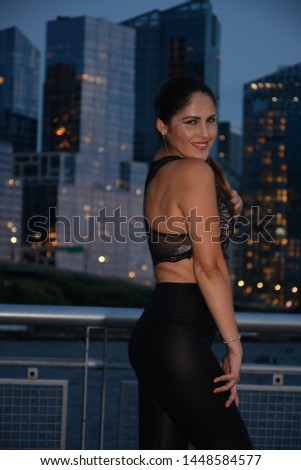 Cute girl from Peru on the pier with Manhattan view at night, New York, USA