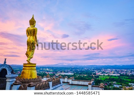 Big Buddha statue on the mountain, the background is the city view, Nan province, Thailand.