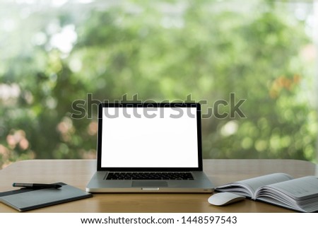 Workspace wooden with desk  Mockup - Laptop with blank screen and wireless mouse and graphics tablet and notebook ,Bokeh Tree Garden Blur Background. - Image