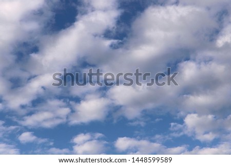 Background of blue sky texture with white fluffy clouds. Horizontal, nobody, place for text. Concept of nature and meteorology.
