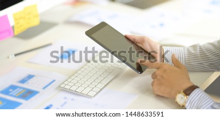 Business man working on tablet computer in modern office, close up of the hand