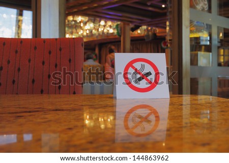 Plate "no smoking" on table in cafe