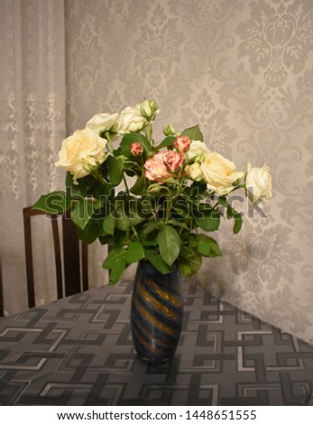 Bouquet of roses in a beautiful blue vase in a cozy room. Composition flowers on the table