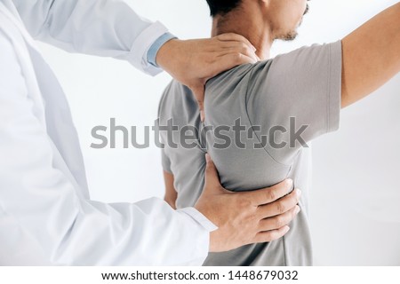 Physiotherapist doing healing treatment on man's back.Back pain patient, treatment, medical doctor, massage therapist.office syndrome Royalty-Free Stock Photo #1448679032