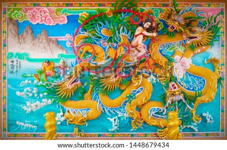 Chonburi, Thailand - July 12, 2019: Nezha god of honour fighting with dragons low and high relief art in Chinese temple.