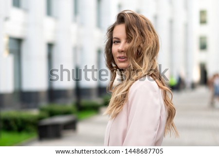 portrait close-up of a girl with long wavy hair, a beautiful natural face without makeup and a sweet smile. Lifestyle Street photography, a cool option for an advertising company