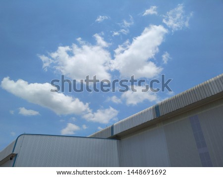 Blue sky with white cloudy among factory building