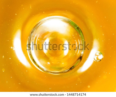Bubbles of air on the smooth surface of golden water as an abstract background .