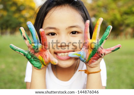 Little girl with hands painted in colorful paint
