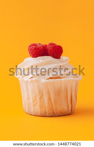 Delicious cupcakes with icing on a yellow background