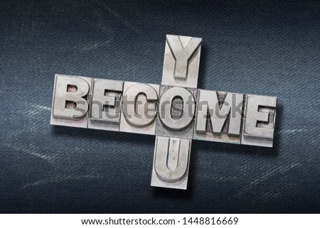 become you crossed phrase made from metallic letterpress on dark jeans background