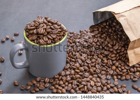 coffee beans in dark coffee cup on dark textured background