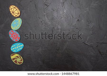Handmade magnets in the shape of Easter eggs on a dark gray concrete background, Ukrainian traditional symbols, copy space, holiday card