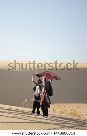 Two Singaporean siblings are posing while holding scarf at Sahara Desert in Egypt 