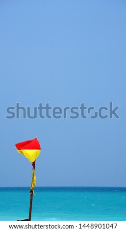 Warning flag at beach by clear blue sky and sea