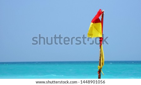 Warning flag at beach by clear blue sky and sea