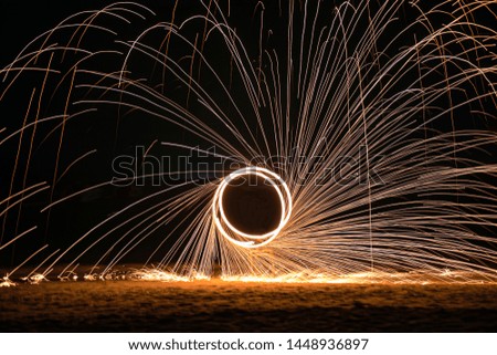 A circle of fire in the night on the beach in island, selection no focus, blurred picture, swing fire dancing show