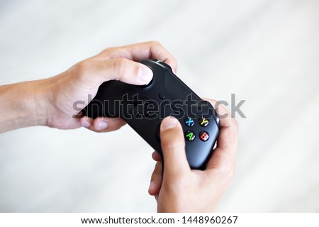 Black joystick in hands isolated on white background. The guy is playing on the console. Computer gaming technology play competition videogame control confrontation concept. Cyberspace symbol
 Royalty-Free Stock Photo #1448960267