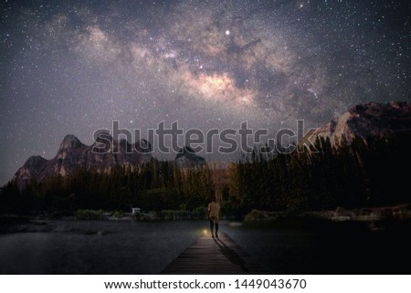 Thought-free, young woman standing at the wooden bridge destination With the Milky Way leaning over the sky at night Royalty-Free Stock Photo #1449043670