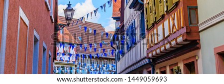 Oktoberfest decoration in the streets of old German town. Old frame houses in german medieval city. Street with traditional Houses and Oktoberfest garland