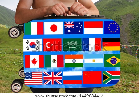 tourist holds with two hands a suitcase with flags of different countries, a symbol of world travel, tourism, immigration, political asylum