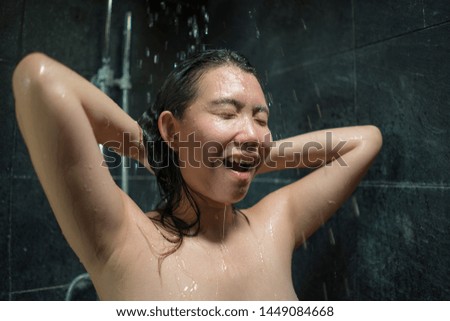 home lifestyle portrait of young beautiful and happy Asian Chinese woman 20s to 30s wet and fresh smiling cheerful taking a shower feeling relaxed with shampoo in her hair