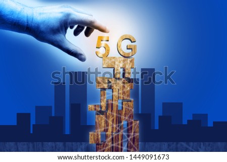 Graphics - 5G tower in gold colour on a blue background with a city diagram and man's hand